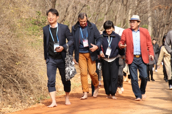 세계기자대회 계족산황톳길 맨발체험_외신기자에게 계족산황톳길 소개중인 조웅래회장(오른쪽).