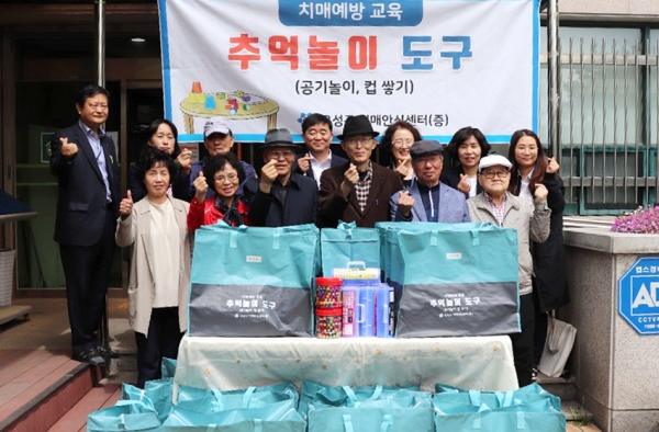 지난 30일 신현정 유성구 치매안심센터장이 치매예방교육에 활용 될 추억 놀이 도구를 ICT 건강지킴이에 전달