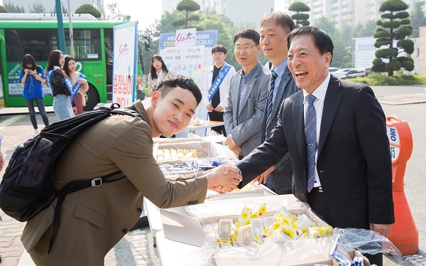김선재(오른쪽) 배재대 총장이 스승의 날을 하루 앞둔 14일 캠퍼스에서 ‘총장님이 쏜다’ 이벤트를 열고 학생들과 악수하고 있다.