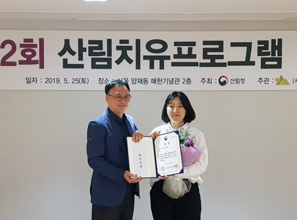 이용권(좌측) 산림청 산림교육치유과장이 지난 25일 서울 서초구 양재시민의숲 윤봉길기념관에서 열린 '제2회 산림치유프로그램 경진대회'에서 정라애(우측) 국립장성숲체원 주임(산림치유지도사)과 기념촬영