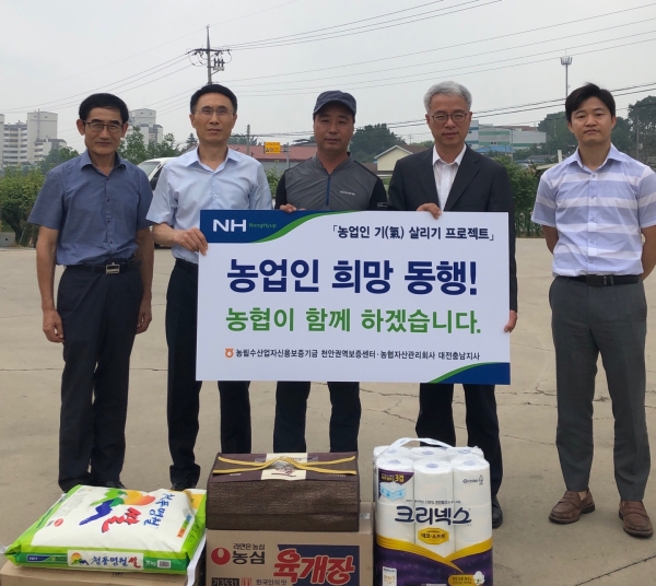 왼쪽부터 농신보천안권역보증센터 윤상팀장, 김인환농신보센터장, 농업인 한모씨, 이웅원 농협자산관리회사 대전충남센터장, 신완섭팀장 등이 ‘농업인 기살리기 프로젝트’ 일환으로 생필품을 전달하고 애로사항을 청취했다.