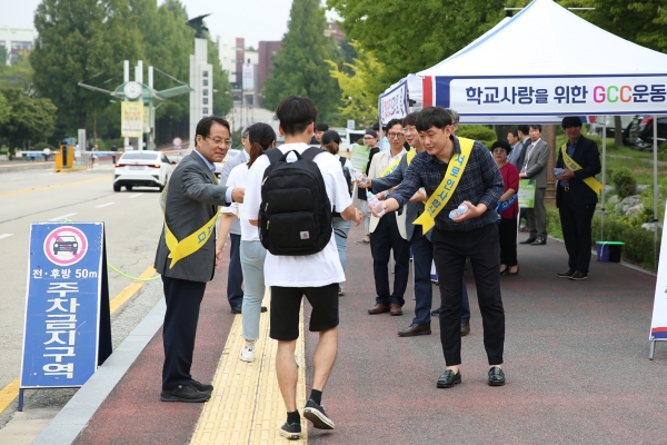 이덕훈 총장(맨 왼쪽)과 김태완 총학생회장(맨 오른쪽), 교직원들이 등교하는 학생에게 생수를 나눠주며 반갑게 인사하고 있다.