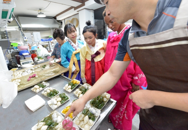 천안중앙시장 최승옥전통폐백이바지에서 외국인 학생들이 송편 설명을 듣고 있다