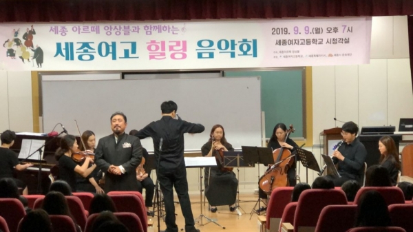 세종여고 학생들이 세종 아르떼 앙상블단이 선사하는 성악과 오케스트라가 함께하는 음악을 들으며 힐링의 시간을 갖고 있는 장면