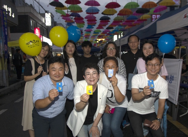 행사장을 찾은 주민과 함께 대덕e로움을 들고 기념 촬영을 하고 있는 박정현 대덕구청장(가운데)