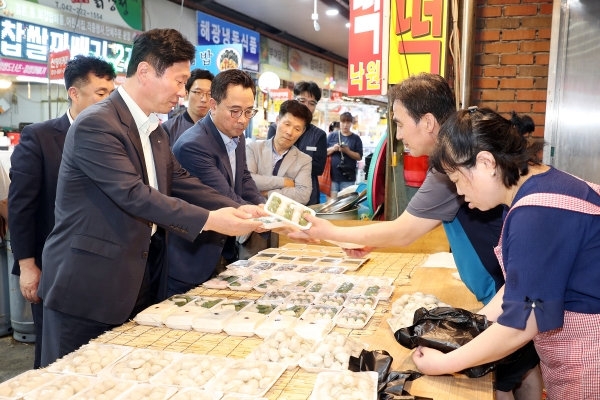 김상균 이사장(왼쪽 1번째)이 전통시장 활성화를 위해 대전 중앙시장에서 물품을 구매하고 있다.