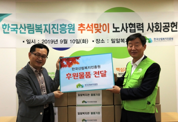 이창재(우측) 한국산림복지진흥원장이 대전시 동구 삼성동에 위치한 밀알복지관에서 '추석맞이 노사협력 사회공헌활동'의 일환으로 권용명 밀알복지관장에게 후원물품을 전달하고 있다.