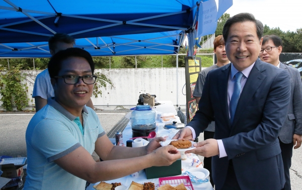필리핀 유학생이 원성수 총장에게 음식을 전달하고 있는 모습