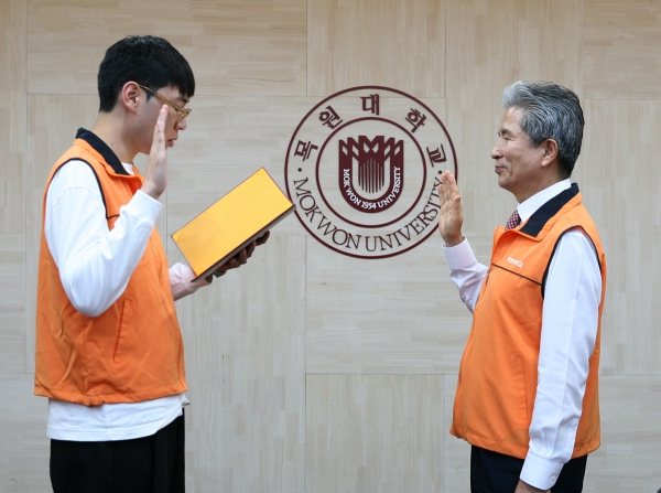 ‘2019-1학기 목원사회봉사단’ 발대식‘에서 봉사단 학생 대표가 권혁대 총장(오른쪽)에게 선서를 하고 있다.