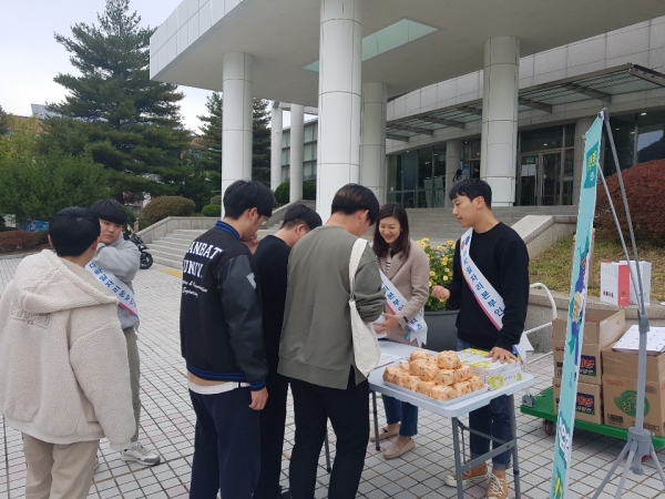 도서관 앞에서 학생들이 청년고용정책 설명을 듣고 기념품을 받고 있다.