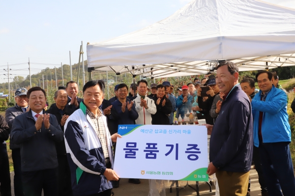 서울지역 농협퇴직동인회 회원들이 예산군 삽교읍 이상복씨 과수농장에서 사과의 상품성을 높이는 작업을 하며 부족일손을 도왔다