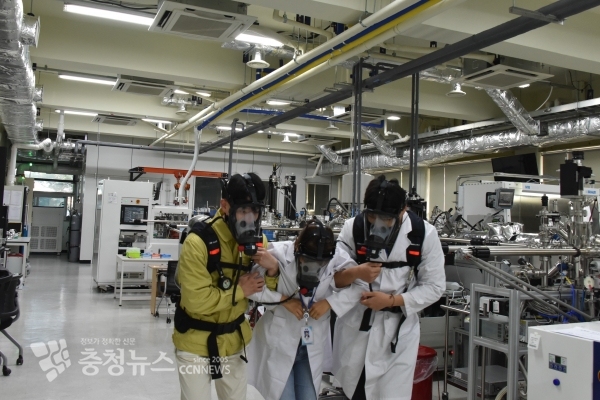 인명구조자가 실험실에 고립된 연구자를 구조하고 있다.