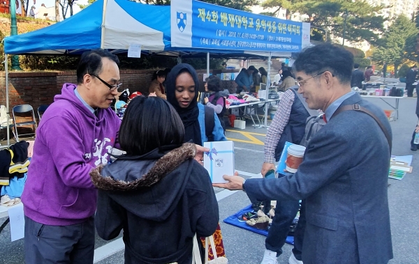 배재대에 재학 중인 한 유학생(가운데)이 6일 배재21세기관에서 열린 유학생을 위한 바자회에서 물품을 구매하고 있