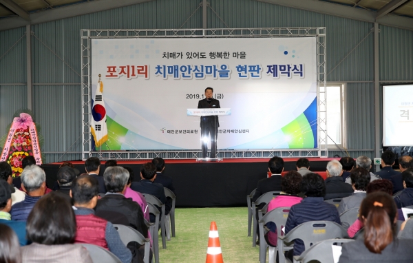 이원면치매안심마을 운영위원 등 150여 명이 모인 가운데 열린 ‘치매안심마을’ 현판식 모습.