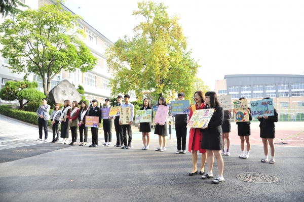 백은희 교장과 학부모, 학생들이 '소통'과 어울림' 캠페인 활동에 참여하고 있다.