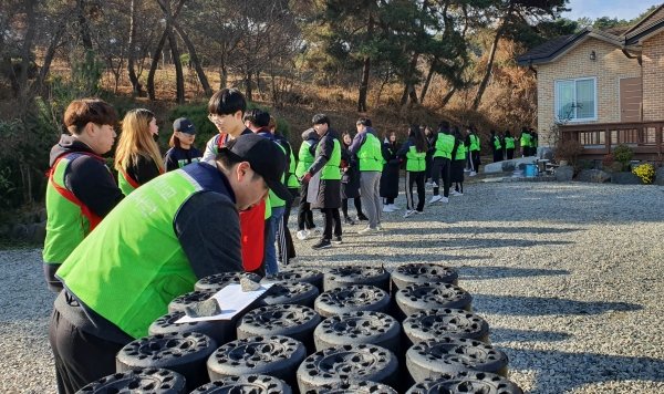 건양대 재학생들이 줄지어 연탄 나눔 봉사활동을 진행하고 있다