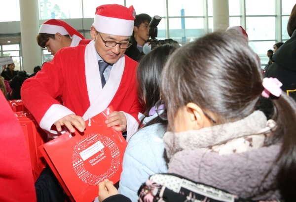 골프존문화재단이 개최한 2019 희망행복나눔페스티벌에서 골프존뉴딘홀딩스 최덕형 대표이사가 소외계층 아동에게 크리스마스 선물을 전달하고 있다.