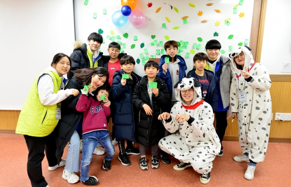 앙트십 트리를 체험한 어린이들이 각자 쓴 긍정 단어를 들어보이고 있다.