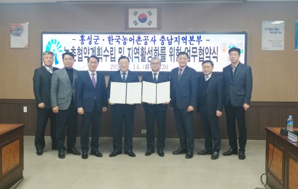 안중식 농어촌공사충남지역본부장(사진왼쪽 협약서) 과 김석환 홍성군수(사진 오른쪽 협약서)가 직원들과 함께 업무협약 기념사진을 찍고 있다.