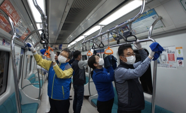 공사 김중철 노동조합위원장과 김경철 사장이 열차 알코올 세척작업을 하고 있다.