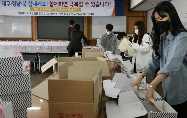 교직원과 학생들이 함께 응원 선물을 포장하고 있다.