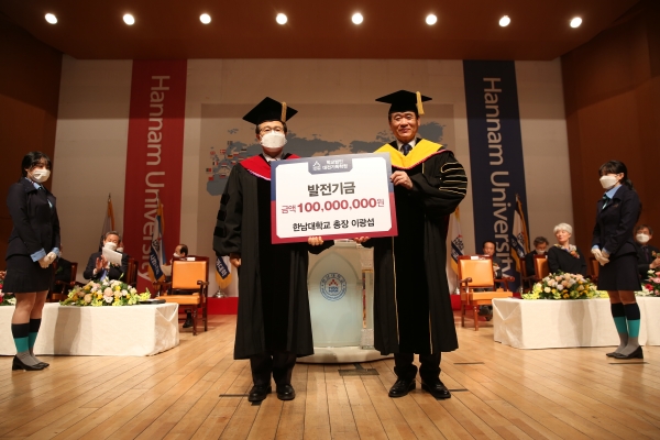 22일 한남대 이광섭 총장이 ‘개교64주년 기념식 및 제17대 총장 취임식’에서 1억 원의 대학발전기금을 대전기독학원 우영수 이사장에게 전달하고 있다.
