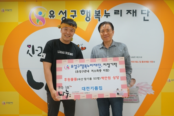 지난 20일 유성구행복누리재단에서 곽형식 대표(왼쪽)가 신동천 유성구행복누리재단 상임이사(오른쪽)에게 기부물품을 전달하고 기념촬영을 하고 있다.