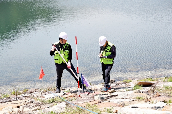 공사직원들이 시설 정밀 측정을 위한 제방 외관조사를 진행하고 있다