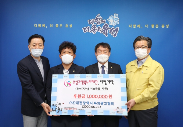 22일 구청 행복사랑방에서 서해성 대표(오른쪽에서 두 번째)가 정용래 유성구청장(맨 오른쪽)과 신동천 유성구행복누리재단 상임이사(맨 왼쪽)에게 코로나19 피해가정을 위한 장학금 100만 원을 전달하고 있다