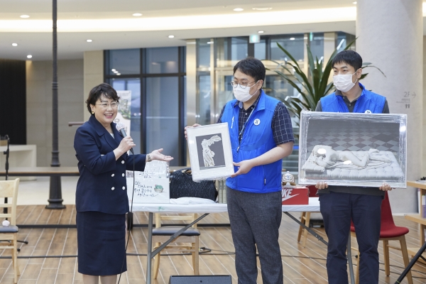 김선민 원장이 바자회에 참여하여  애장품을 소개하고 있다.