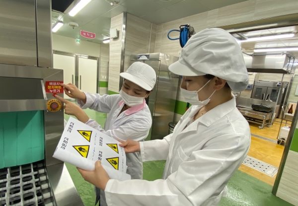 학교 급식실 관계자가 안전 스티커를 부착하고 있다.