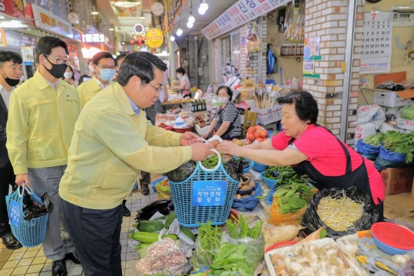 오세현 아산시장이 협약 관계자들과 온양온천전통시장을 방문해 장을 보고 있다.