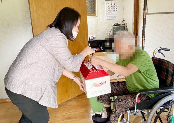 지난 23일 군 복지증진과 직원들이 태안읍의 한 독거노인 가구를 찾아 손수 만든 송편을 비롯한 음식(불고기ㆍ김치ㆍ식혜)이 담긴 박스를 전달하는 모습.