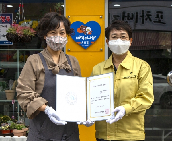 박정현 대덕구청장이 신탄진동 ‘대청화원’을 대덕e나눔 6호점 지정하고 현판을 걸고 있다