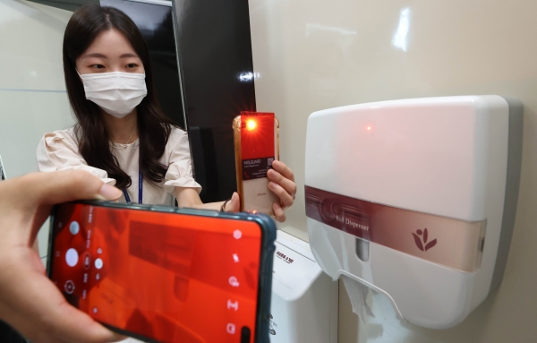 동구청 직원이 배포된 불법촬영 카메라 감지카드로 화장실을 점검 중이다