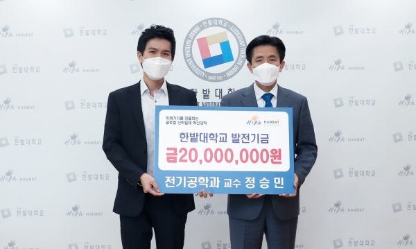 전기공학과 정승민 교수가 발전기금을 전달하고 한밭대 최병욱 총장(오른쪽)과 기념촬영을 하고 있다.