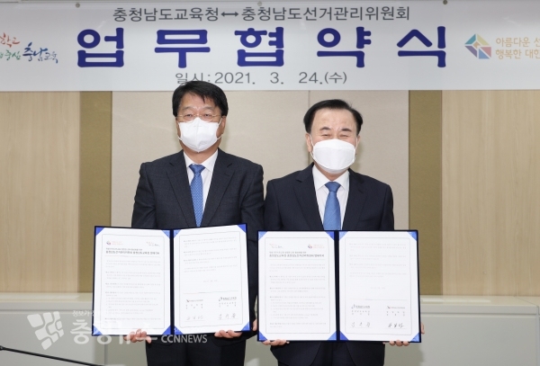 송봉섭 충남선관위 상임위원(왼쪽)과 김지철 충남교육감이 업무협약서에 서명한 후. 기념촬영을 하고 있다.