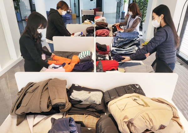 지난 25일 천안소재 에스엘홀딩스 사옥에서 그룹 구성원들이 ‘2021 의류 리사이클링 캠페인’을 위해 기부된 의복을 선별 및 분류하고 있다.