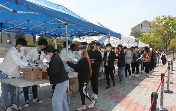 21일 정오 목원대학교 중앙도서관 광장에서 총학생회 관계자들(왼쪽)이 학생들에게 도시락을 전하고 있다.
