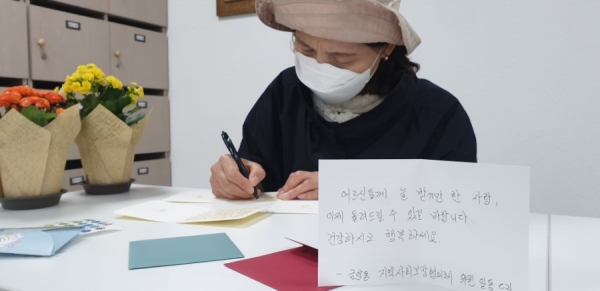 금암동 주민참여형 마을복지사업(독거노인과 한부모가정 아동에 편지를 쓰는 모습)