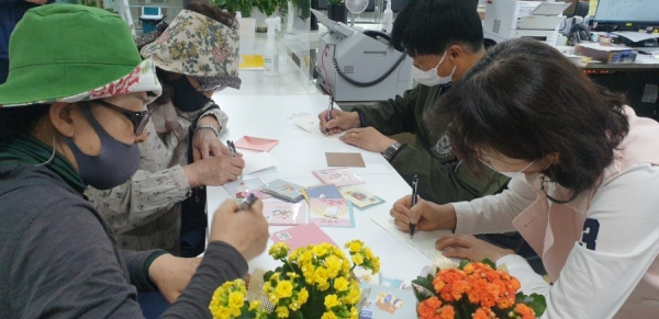 금암동 주민참여형 마을복지사업(독거노인과 한부모가정 아동에 편지를 쓰는 모습)