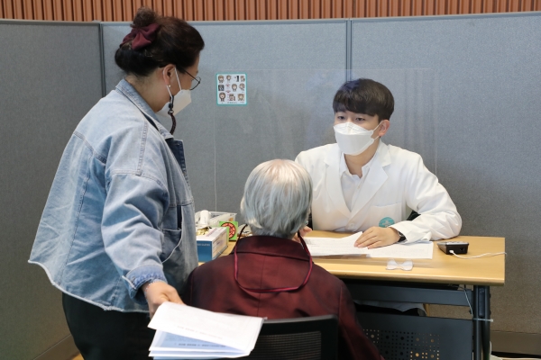 접종센터에서 어르신이 예진을 받고 있는 사진