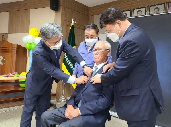 영인농협에서 열린 2021년 첫 번째 농업인 행복버스 봉사활동에서 충남세종농협 길정섭 본부장(왼쪽), 영인농협 박종성 조합장(가운데 뒤쪽), 농협아산시지부 진문종 지부장(오른쪽)이 장수사진 촬영을 돕고 있다.