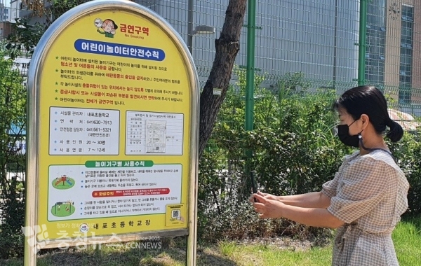 내포초등학교 어린이놀이시설 안내판에 부착된 스마트 안전관리시스템 QR코드를 인식하는 모습