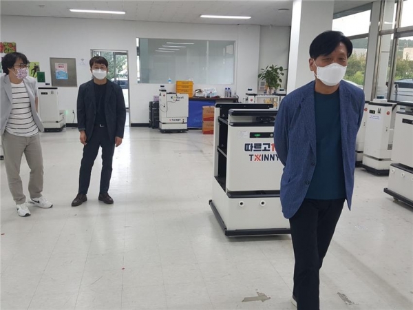 조승래 국회의원(오른쪽)이 트위니가 개발한 대상 추종로봇 따르고100을 체험하고 있다