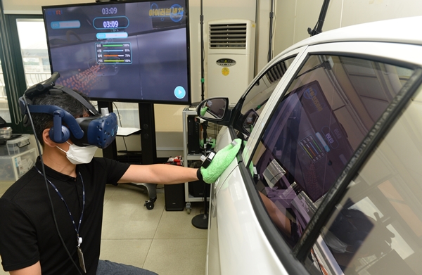 ETRI 연구진이 스팀세차 가상 직업훈련을 위한 VR 기술 시연을 하고 있는 모습