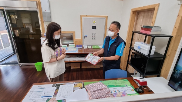 경기 양평군 국립하늘숲추모원 방문객(좌측)이 지난달 지역상권 활성화 이벤트에 참여해 직원으로부터 증정품(구급함)을 건네받고 있다