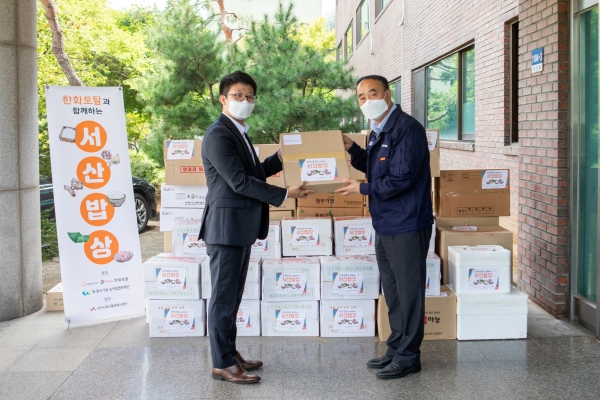 지난 9일 한화토탈 직원(사진 왼쪽)이 고객사 삼동산업을 방문해 삼동산업 김태규 이사(사진 오른쪽)에게 서산지역 특산물을 전달하는 모습