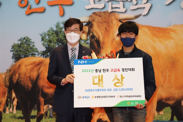 2021년 충남 한우 고급육 경진대회에서 정낙춘 충청남도 농림축산국장(왼쪽)이 충남 최고 한우농가로 선정된 세종공주축협 이수명 조합원(오른쪽)에게 영예의 대상을 시상했다.