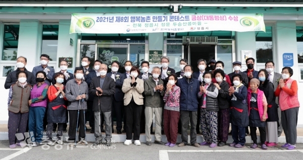 제8회 행복농촌만들기 콘테스트 대통령상을 수상한 정읍시 정문두승산콩마을 주민들이 현판 앞에서 기념사진을 찍고 있다.